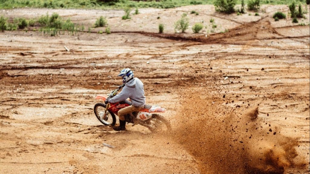 Guy Riding Dirt Bike in dirt for a contact page banner